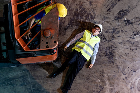 亚洲仓库经理在叉车事故发生后躺在仓库地板上使用安全第一概念空中最高视图图片