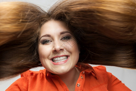 长棕色头发的快乐女展示她健康的发型头护理概念图片