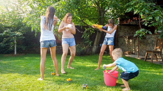 41愚乐行动喜笑家庭与孩子们在热暑日玩得开心的美丽照片他们有水和花园龙头家庭在夏季玩耍和户外乐喜笑家庭与孩子们在热暑日玩得开心的美丽形象他们背景