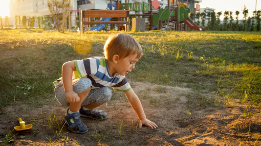 3岁男孩坐在公园和挖沙的地上图片