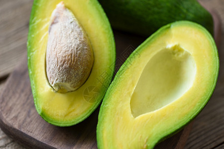 Avocado在木制切板上一半用于avocado沙拉水果健康食品概念图片