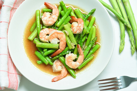 Asparagus虾海食品烹饪健康白盘上绿色的斯蒂尔炸虾图片
