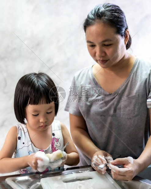 女孩与母亲一起洗盘子和餐具图片