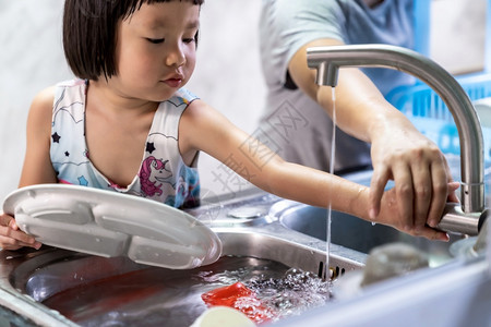 女孩与母亲一起洗盘子和餐具图片