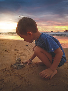 可爱的幼儿男孩在苏斯奈海滨玩沙子可爱的幼儿男孩在苏斯涅海滨玩沙子的陶照片图片