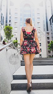 身着短裙长腿的漂亮年轻女子在市街的石楼梯上行走图片