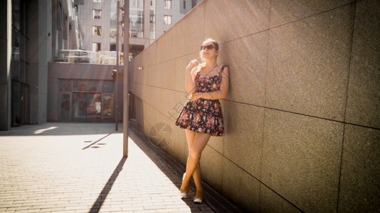 长发唯美飘飘阳光明媚的在街上石墙倾斜着长发的美丽女人肖像背景