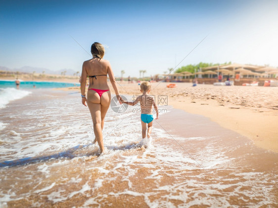 母亲和儿子在沙滩上行走图片