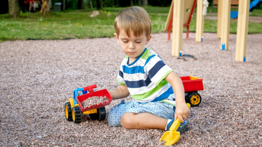 玩沙子正在给玩具卡车装沙子的男孩背景
