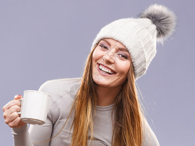 穿着冬季羊毛帽的长发女郎拿着杯茶热饮的子图片