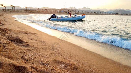 漂浮在海上的充气机动艇美丽照片它漂浮在海浪上以抵御美丽的日落漂浮在海浪上的充气机动艇美丽图像以抵御美丽的日落图片