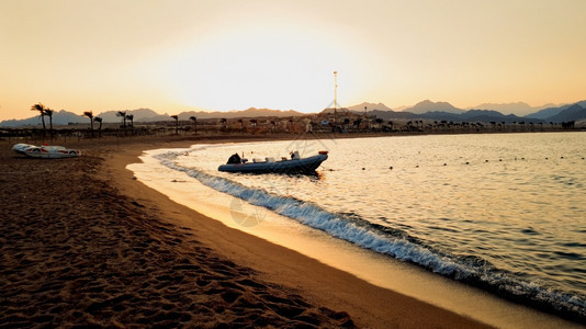 漂浮在海上的充气机动艇美丽照片它漂浮在海浪上以抵御美丽的日落漂浮在海浪上的充气机动艇美丽图像以抵御美丽的日落图片