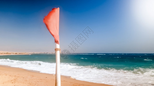 红色警示旗在海上的强风下飘动图片