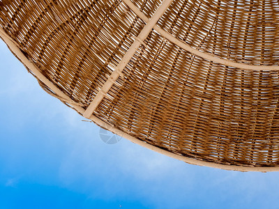 保护沙滩上太阳免受蓝天照射的稻草伞部分贴合照片夏季假日或期的景象文本位置复制空间保护海滩上太阳免受蓝天照射的部分草伞贴近图像夏季图片