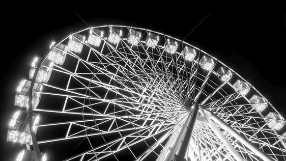 黑色和白照片夜晚在游乐园中旋转的发酵轮晚上在游乐园中旋转的发酵轮晚上在游乐园中旋转的发酵轮黑和白色图像图片