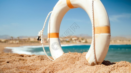 在阳光明媚的白天在海滨上白色塑料救生圈的近距离照片完美的镜头可以说明暑假在海洋中白色塑料救生圈在阳光明媚的白天在海滨上近距离图像图片