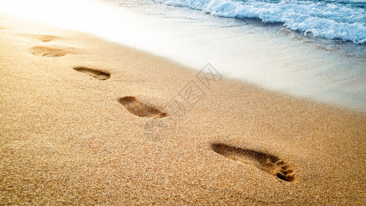 脚步水面的美丽日落海面的湿沙上人类足迹与水面的美丽日落图像与水面的美丽日落图像与水面的美丽日落相近背景