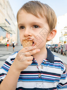 男孩在街上吃巧克力冰淇淋图片