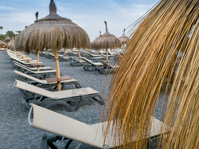 以海滨棕榈叶制成的太阳雨伞近照图片