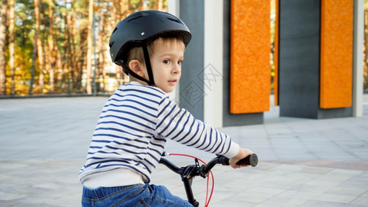 骑自行车时穿戴防护头盔的小男孩肖像图片