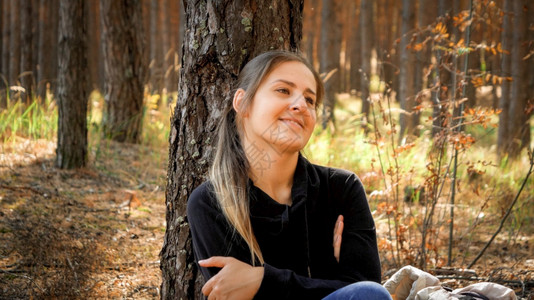 在森林中长途跋涉之后在地上放松林中长途跋涉之后在地上放松的美丽微笑女游客肖像图片