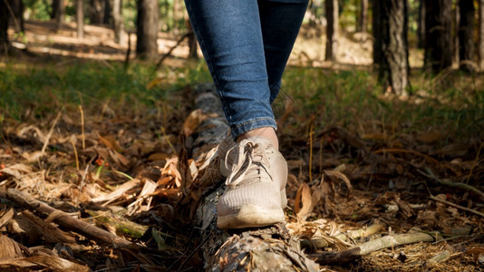 女穿着运动鞋在森林的地面上行走和平衡图片