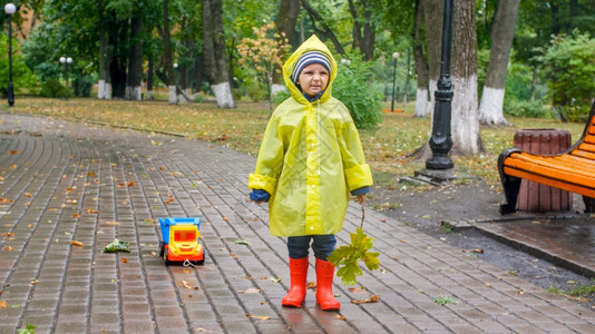 雨天在公园穿雨衣玩耍的男孩图片