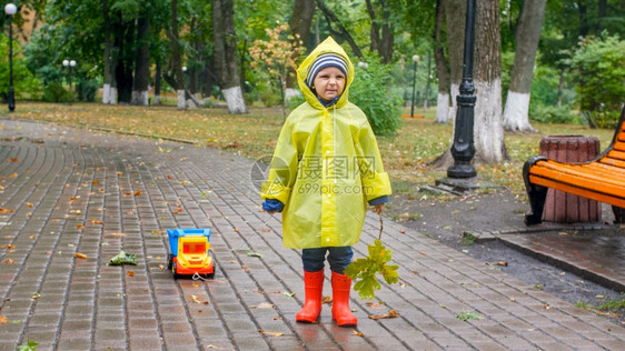 雨天在公园穿雨衣玩耍的男孩图片