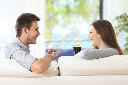 幸福的一对情侣聊天在家沙发上喝咖啡的简况图片