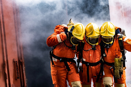 亚洲消防员从燃烧的建筑中救出他们的团队同事从故和公共服务概念中救出消防员的安全救援图片