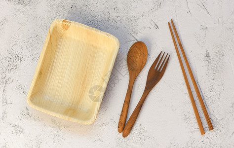 来自棕榈叶或贝壳坚果零废物环境概念自然生态友好食品包装配有盘子和木叉的一次餐具图片