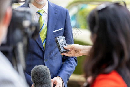 在与商界人士举行新闻发布会或简报时拥有麦克风和数字语音录机的记者图片