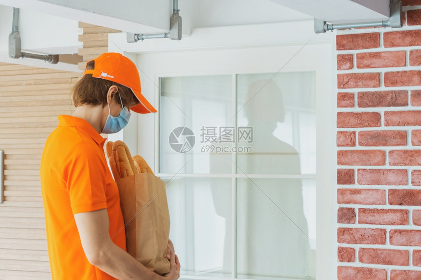带面罩和制服的送货员在顾客家门前送货袋内装包裹箱网上购物和检疫概念中快餐送货高清图片下载 正版图片 摄图网 带面罩和制服的送货员在顾客家门前送货袋内装包裹箱网上购物和检疫概念中快餐送货高清图片下载 正版图片 摄图网