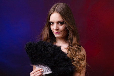 女美貌的眼神化妆握着狂欢节羽毛的风扇狂欢节新年庆祝活动的概念女拿着狂欢节羽毛的风扇背景图片