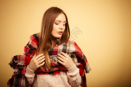 穿着暖秋衣羊毛的长头发年轻妇女检查了蜜蜂上的围巾制片人拍摄了工作室穿着羊毛的妇女检查了围巾的温暖秋日服装图片