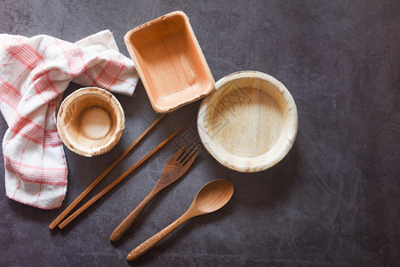 筷子包装来自棕榈叶或贝壳坚果零废物环境概念自然生态友好食品包装配有盘碗杯和木叉勺的一次餐具背景