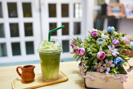 绿茶冰沙Matcha绿茶咖啡馆桌上的茶有塑料玻璃的牛奶图片