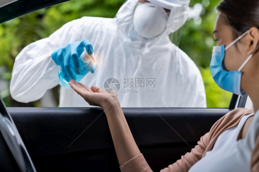 医务人员在院的车道站进行科罗纳新冠viruscovid19测试之前先向亚洲妇女提供酒精凝胶手扫荡剂图片