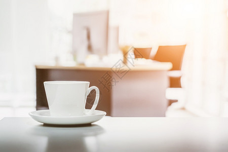 咖啡杯放在办公桌上有现代办公室的背景休息时间图片