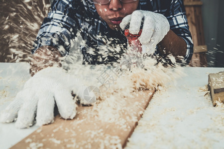 在生产建筑材料或木制家具的讲习班上从事木制工艺的的亚洲青年制的的图片