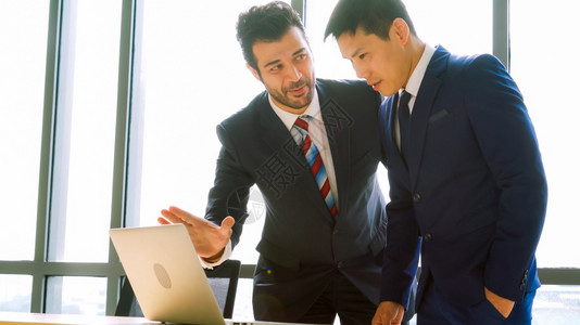 导师背影两个商人在办公室会议谈论项目战略商人与现代工作场所的同事