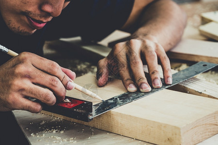 在生产建筑材料或木制家具的讲习班上从事木制工艺的的亚洲青年制的的图片