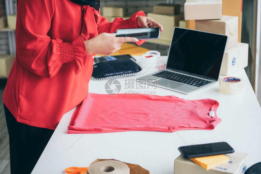 网上销售者在家庭办公室工作将货运箱包装给客户小业主或在因特网上从事电子商务业的企家图片