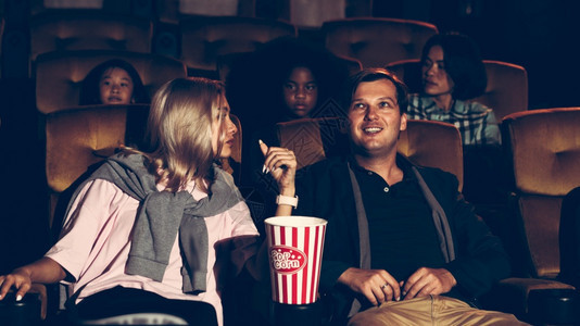 观众走在电影院的座位上观看电影和吃爆米花图片
