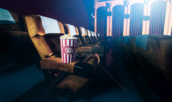 在电影院的一排黄色座位上 椅子有爆米花图片
