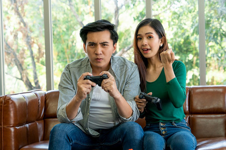 快乐的亚洲夫妇在客厅玩电子游戏图片