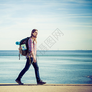 在海边行走的背包客图片