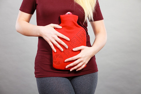 女腹部疼痛有热红水瓶腹部有热红水瓶卫生保健止痛的治疗概念胃痛的女孩有热水瓶图片