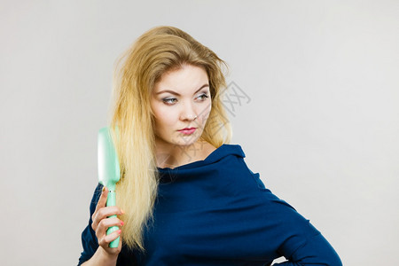 年轻女有着美丽的天然金发直长头工作室拍摄在灰色上图片