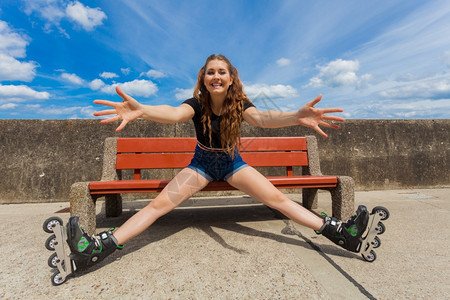 快乐的年轻女子穿着滑冰鞋在长途旅行后放松图片
